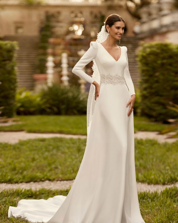 Robe de mariée coupe A-line, crêpe, dentelle, décolleté V, manches longues.